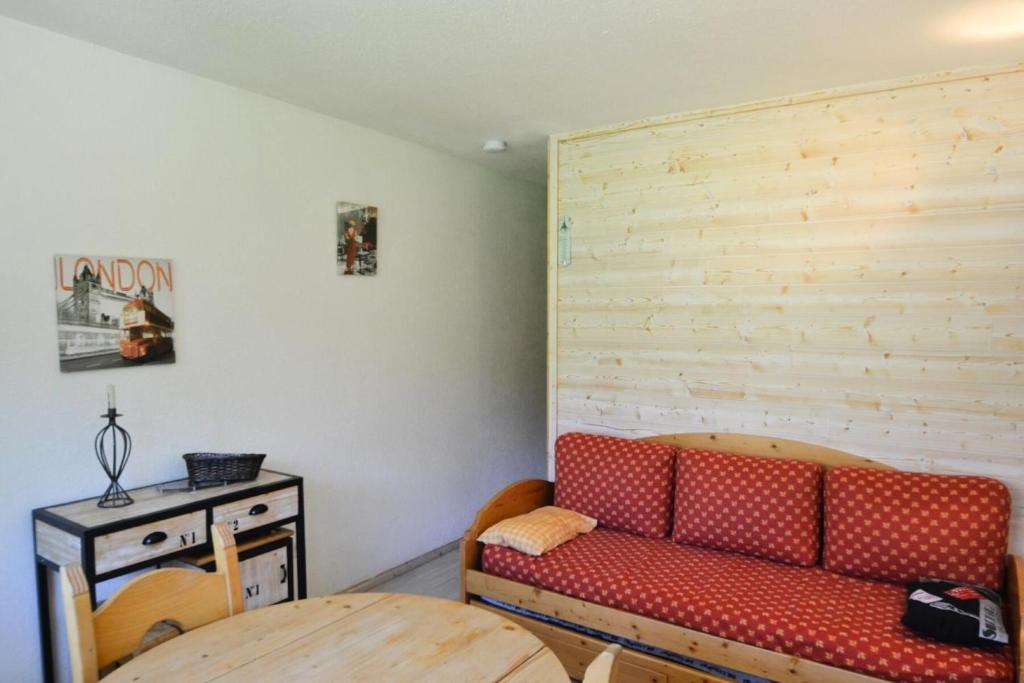 un salon avec un canapé rouge et une table dans l'établissement Résidence Le France - Studio 3/4 pers - LE FRANCE - PLAGNE CENTRE MAE-1784, à Aime La Plagne