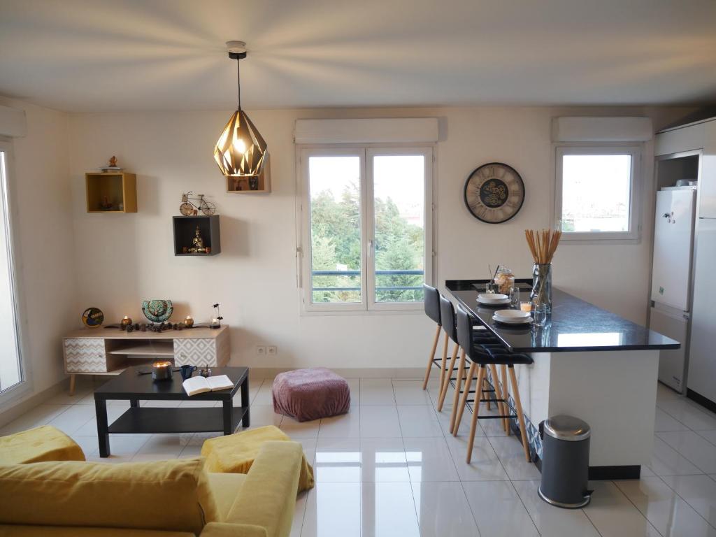 une cuisine et un salon avec un comptoir noir dans l'établissement Appartement à 15 minutes de Paris, proche gare, au Bourget