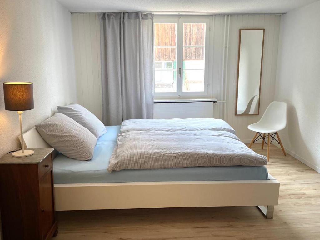 a bedroom with a bed with a lamp and a window at Charmante Wohnung im alten Dorfkern in Winterthur
