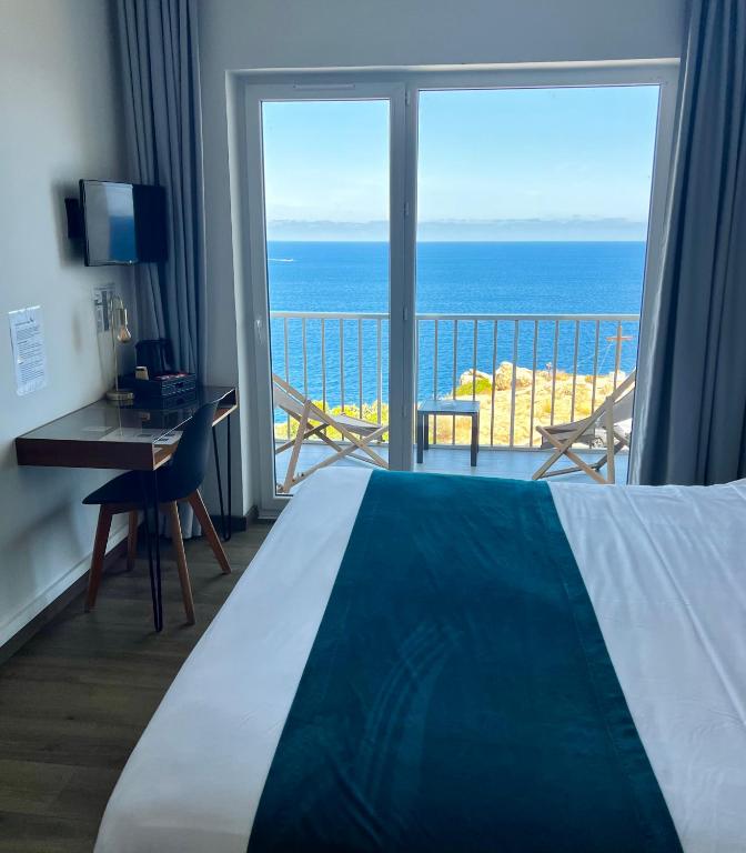 a bedroom with a bed and a view of the ocean at Il Tramonto in Calvi