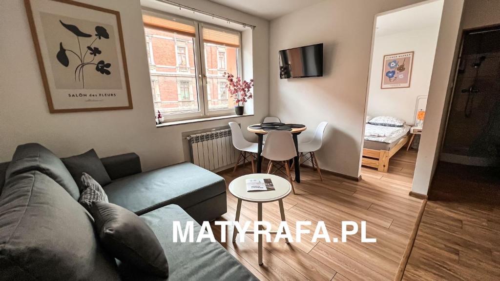 a living room with a couch and a table at ApartamentsByMatyrafa-IV in Tarnowskie Góry