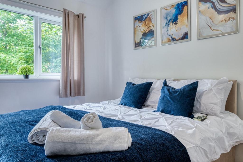 a bedroom with a large bed with towels on it at Full House, Massage Mattresses, Sleeps 6 guests, Free wifi, Free Parking, Free Netflix, Smart TV in Manchester
