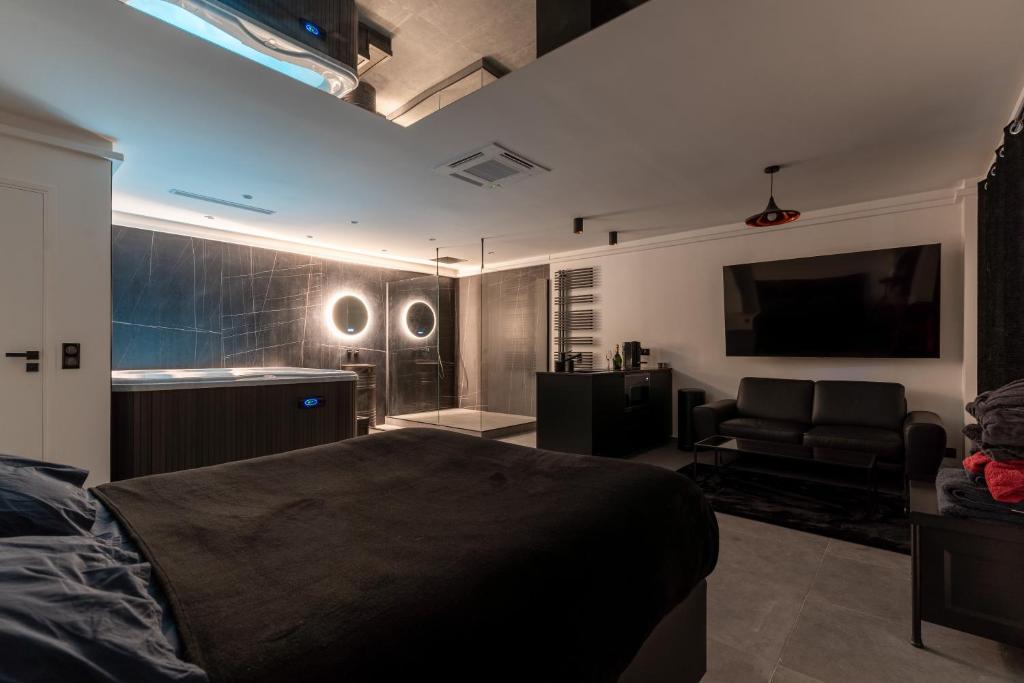 une chambre avec un lit, un canapé et une télévision dans l'établissement SUITE Esbly, Jacuzzi, Terrasse, Disneyland, à Esbly