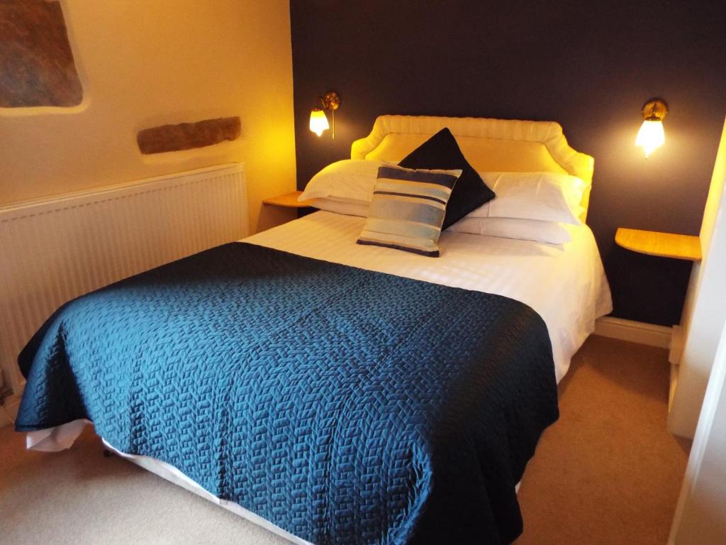 a bedroom with a large bed with two pillows at The Board Inn in Hawes