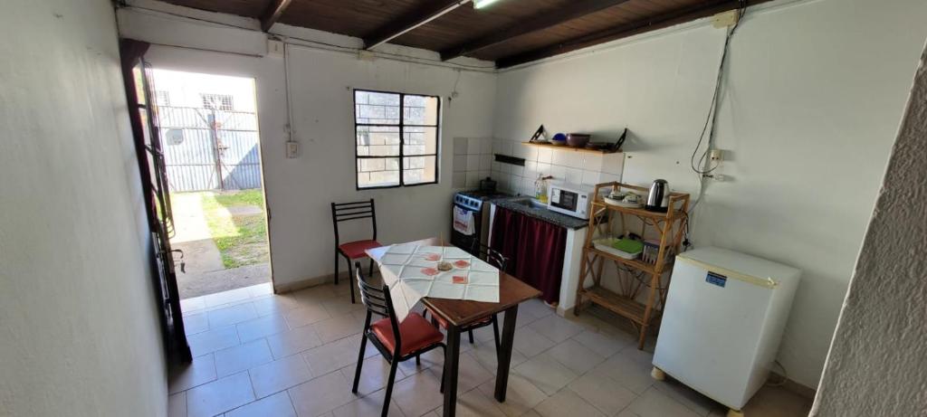 Una pequeña cocina con una mesa y un refrigerador. en Centrico , acogedor y economico, en Mercedes