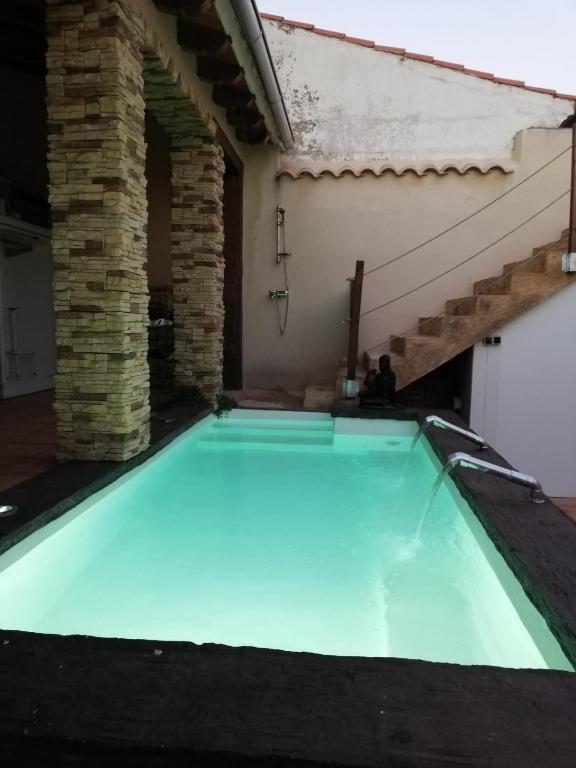 a large swimming pool in a house with a brick wall at Ala Pa cá in Miajadas
