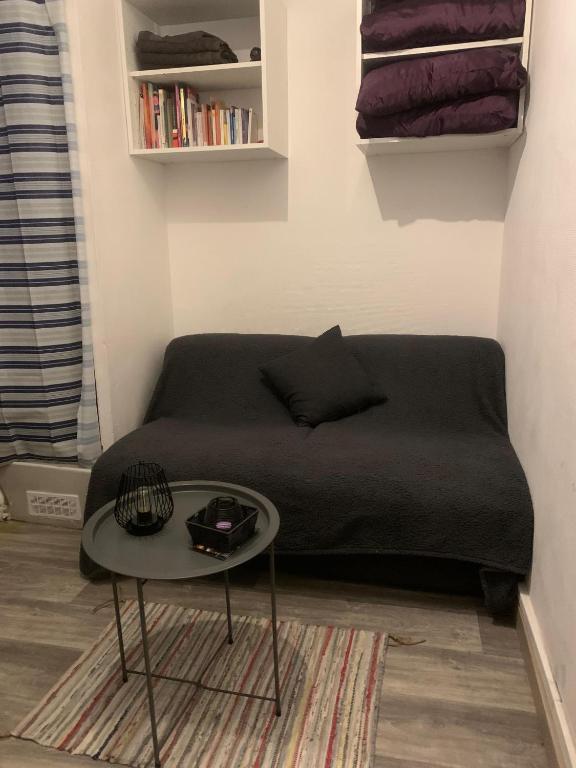 un salon avec un canapé et une table dans l'établissement Studio Paris Charonne, à Chennevières-sur-Marne