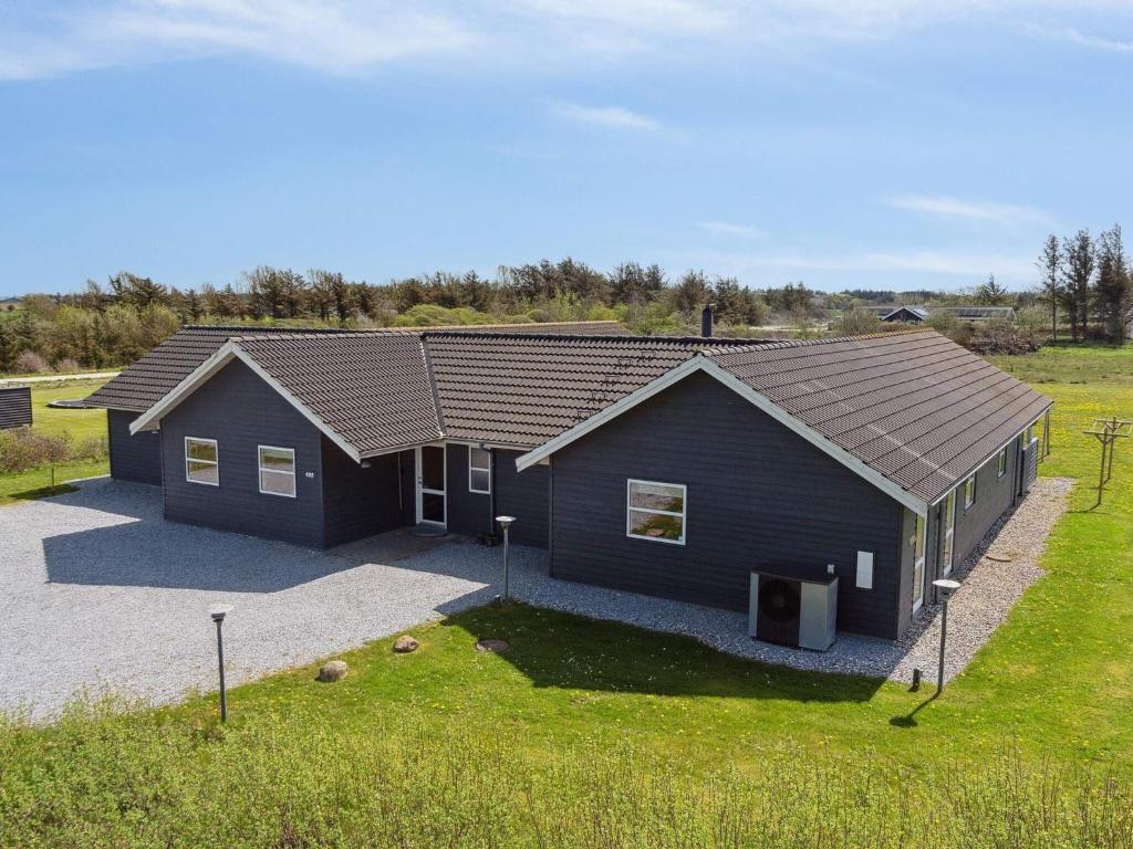 een blauw huis in het midden van een veld bij Luxury Retreat Nr Lyngby - By Traum Ferienwohnungen in Nørre Lyngby