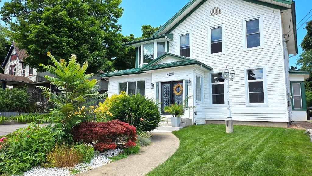 una casa bianca con un giardino di fronte di Serenity Inn a Niagara Falls