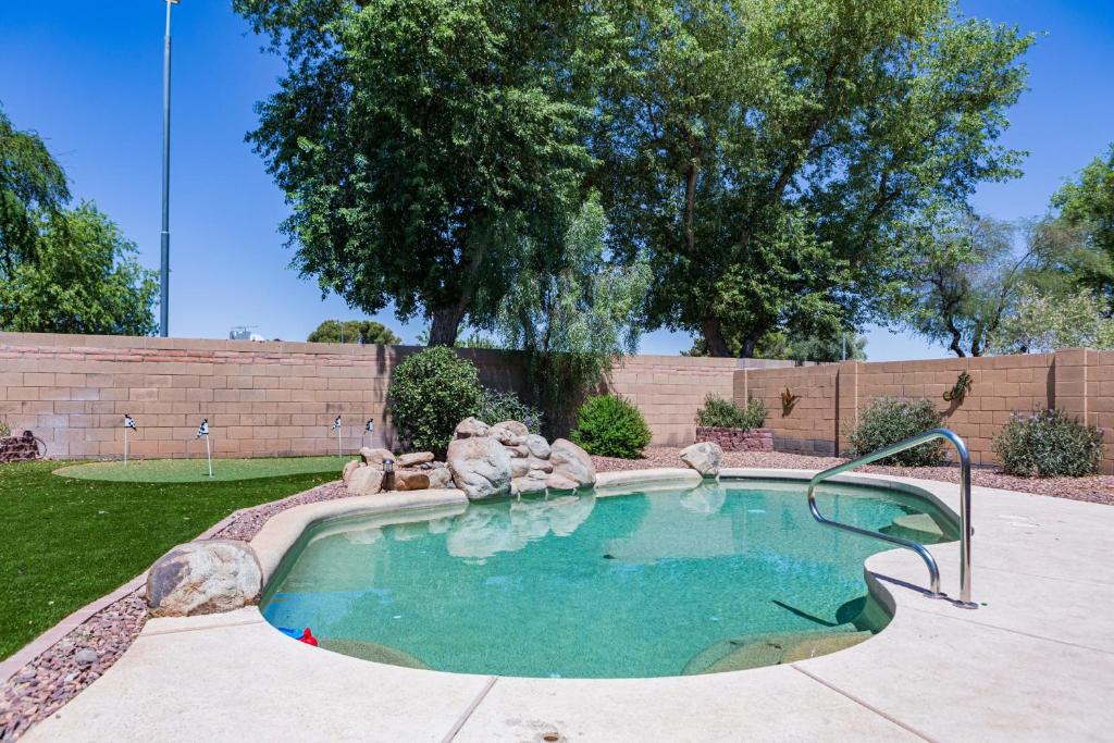 a swimming pool with a fountain in a yard at Sun-Kissed Gem - Pool Heater Golf Green AZ Room in Peoria