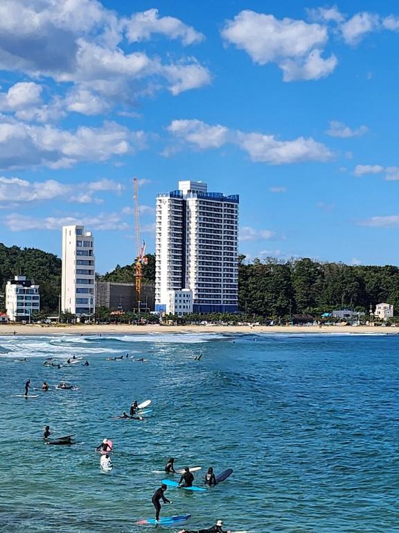 eine Gruppe von Menschen, die im Meer schwimmen in der Unterkunft Ocean Stay Yangyang 1318 오션스테이 양양 E7 in Yangyang
