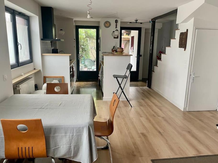 a room with a table and chairs and a kitchen at Maison proche Paris Stade de France in Aubervilliers