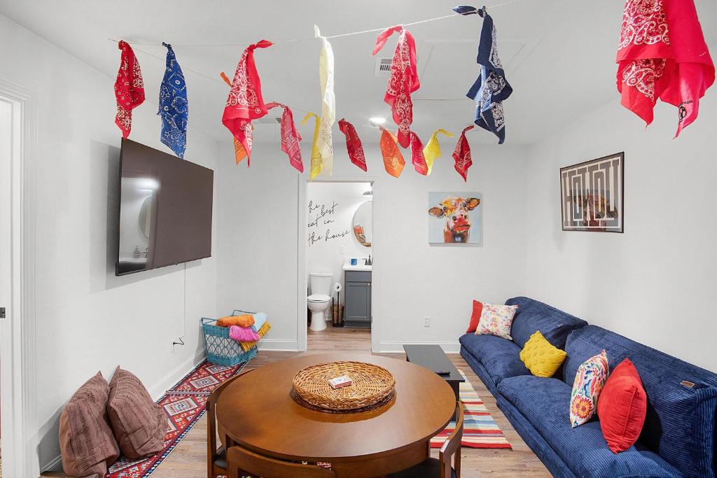 ein Wohnzimmer mit einem blauen Sofa und einem Tisch in der Unterkunft LaTexienda - 7min to A&M - Firepit - Volleyball - BBQ in College Station