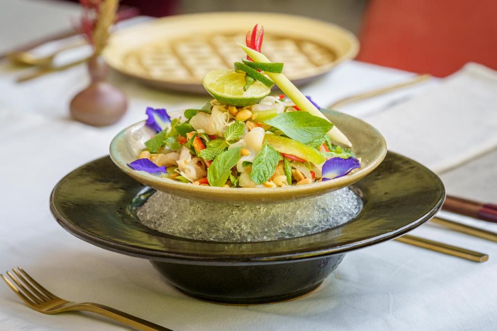 a bowl of food on a plate on a table at Viroth's Hotel in Siem Reap