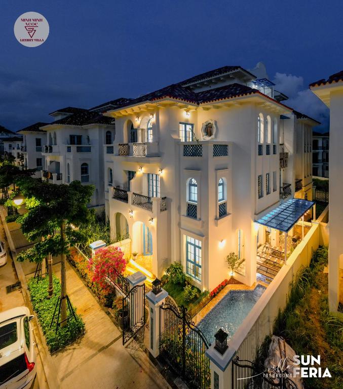 a large white house with a swimming pool at night at Sun Villa 7 br & pool in Ha Long