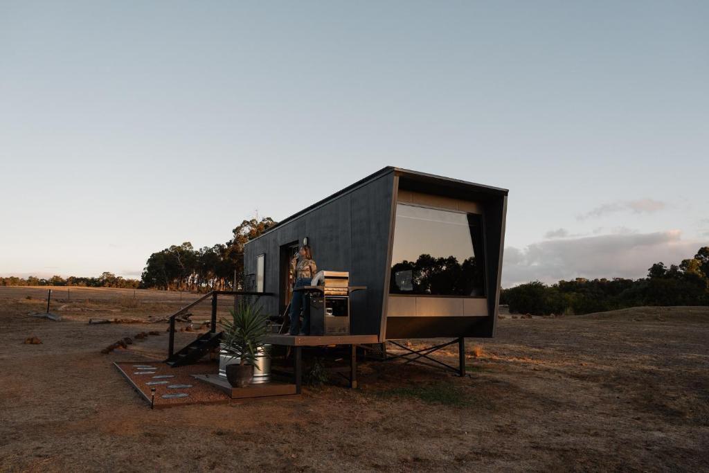 a person standing inside a tiny house in a field at Heyscape Busselton in Busselton
