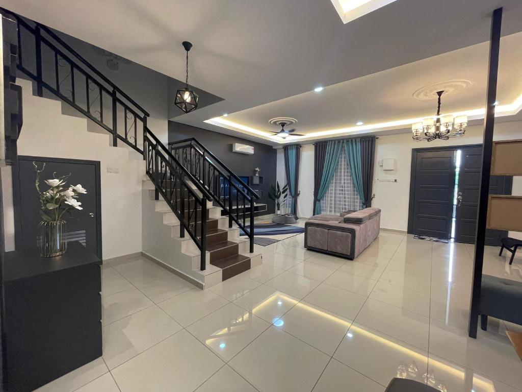 a living room with a staircase and a couch at D’Lora Homestay in Melaka