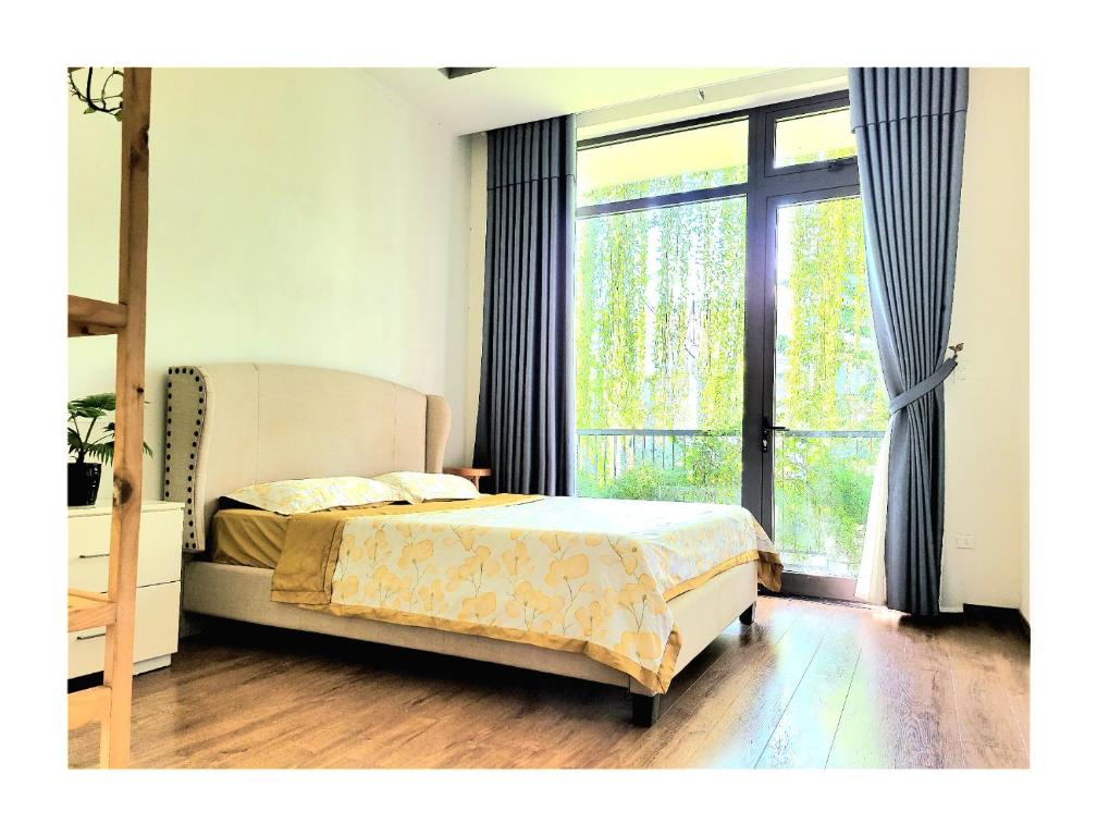 une chambre avec un lit et une grande fenêtre dans l'établissement Sunshine villa, à Ấp Long Hồ Hạ