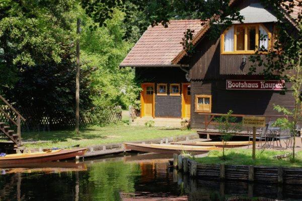 a house next to a river with a house at Bootshaus Kaupen in Kaupen