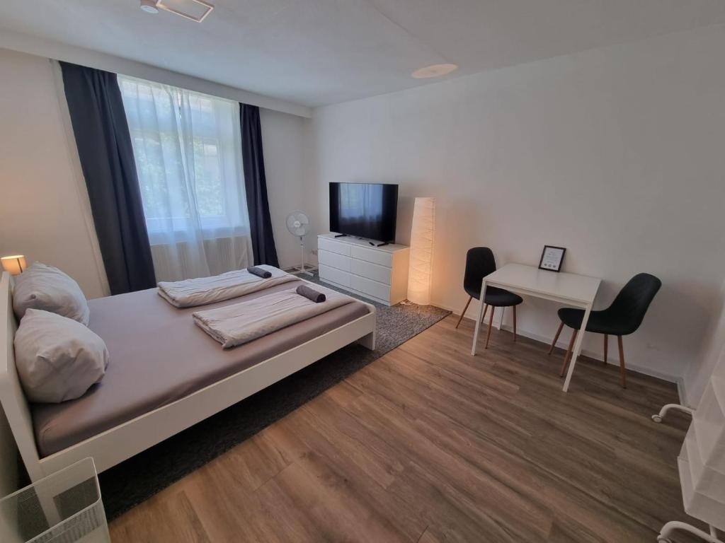 a bedroom with a bed and a desk and a television at Süße Marie 5 in Karlsruhe