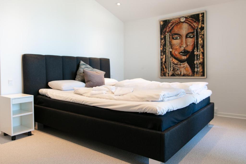 un grande letto in una stanza con un dipinto sul muro di Strandhuset. ad Asperup
