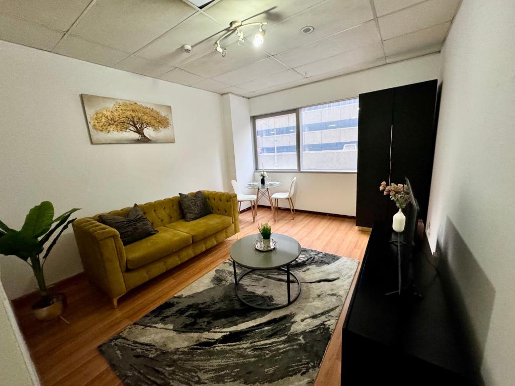 una sala de estar con un sofá y una mesa en Colosseum Apartments, en Johannesburgo