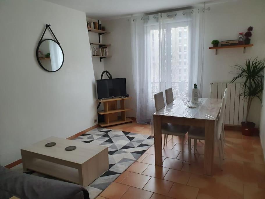 un salon avec une table et un canapé dans l'établissement Joli deux pièces au 14ème arrondissement à Paris, à Paris