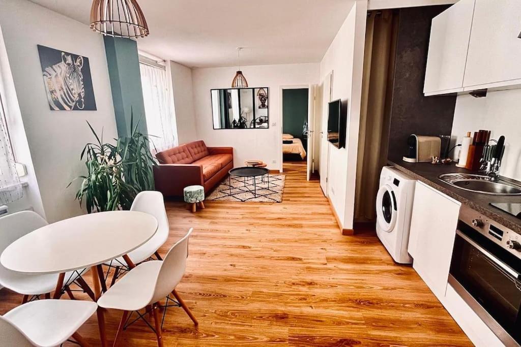 une cuisine et un salon avec une table et des chaises dans l'établissement Appartement cosy au centre-ville, à Haguenau