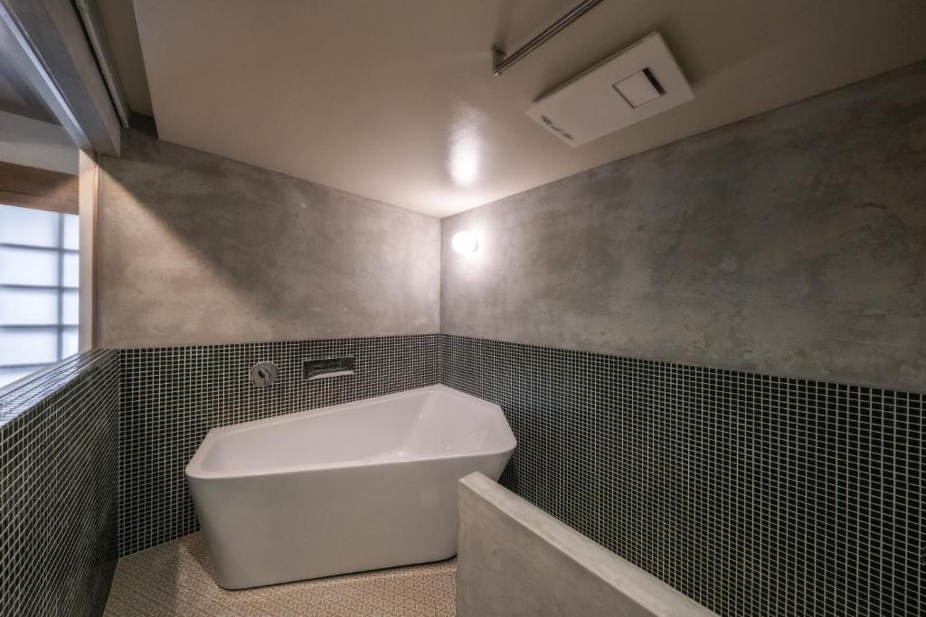 グループに最適The Bath & Bed Dogo 築110年の蔵をリノベした源泉掛け流し一棟貸しの温泉宿にあるバスルーム