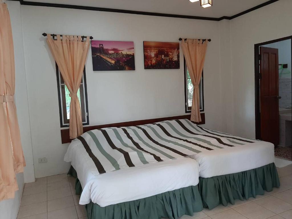 Postel nebo postele na pokoji v ubytování บ้านพาสุขรีสอร์ท