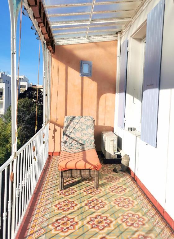 une chaise assise sur un balcon avec un tapis dans l'établissement T2 Ambiance zen, hyper calme au coeur de Valence, à Valence