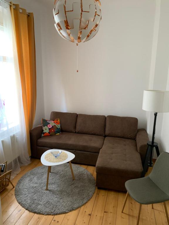 a living room with a brown couch and a table at Ferienwohnung am Tivoli in Freiberg