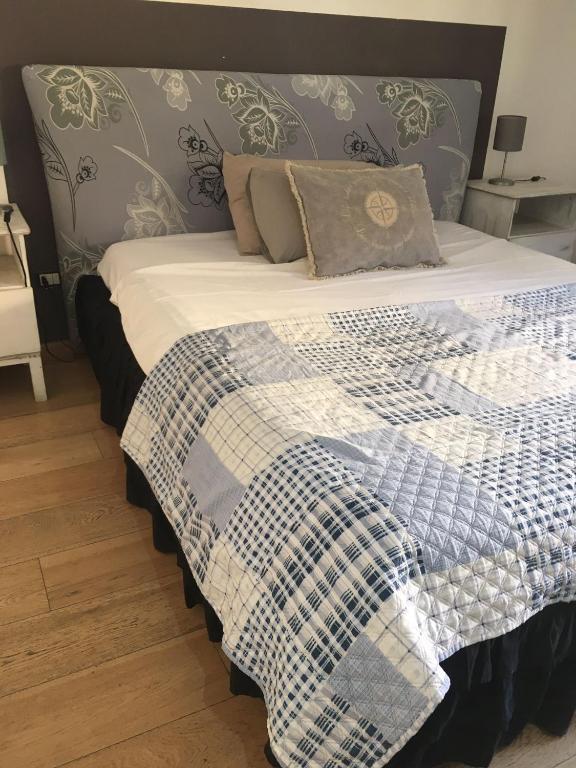 uma cama com um cobertor azul e branco em B&B Affaccio sul Vaticano em Roma