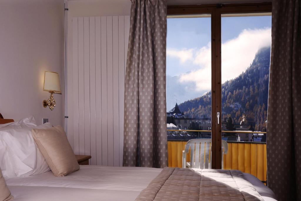 Postel nebo postele na pokoji v ubytování Hotel Schweizerhof Pontresina