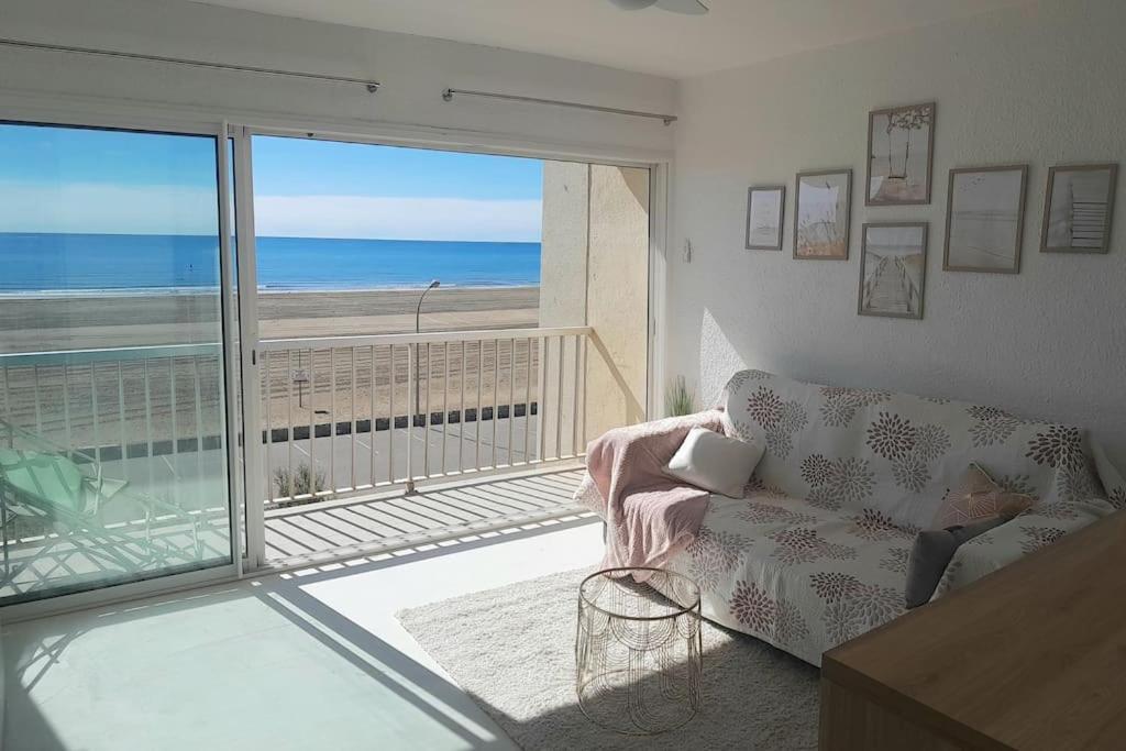 Una sala de estar con un sofá y vista al mar. en La PLage, en Port-la-Nouvelle