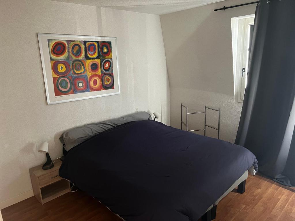 une chambre avec un lit et un tableau au mur dans l'établissement Au cœur du quartier historique de Moulins, à Moulins