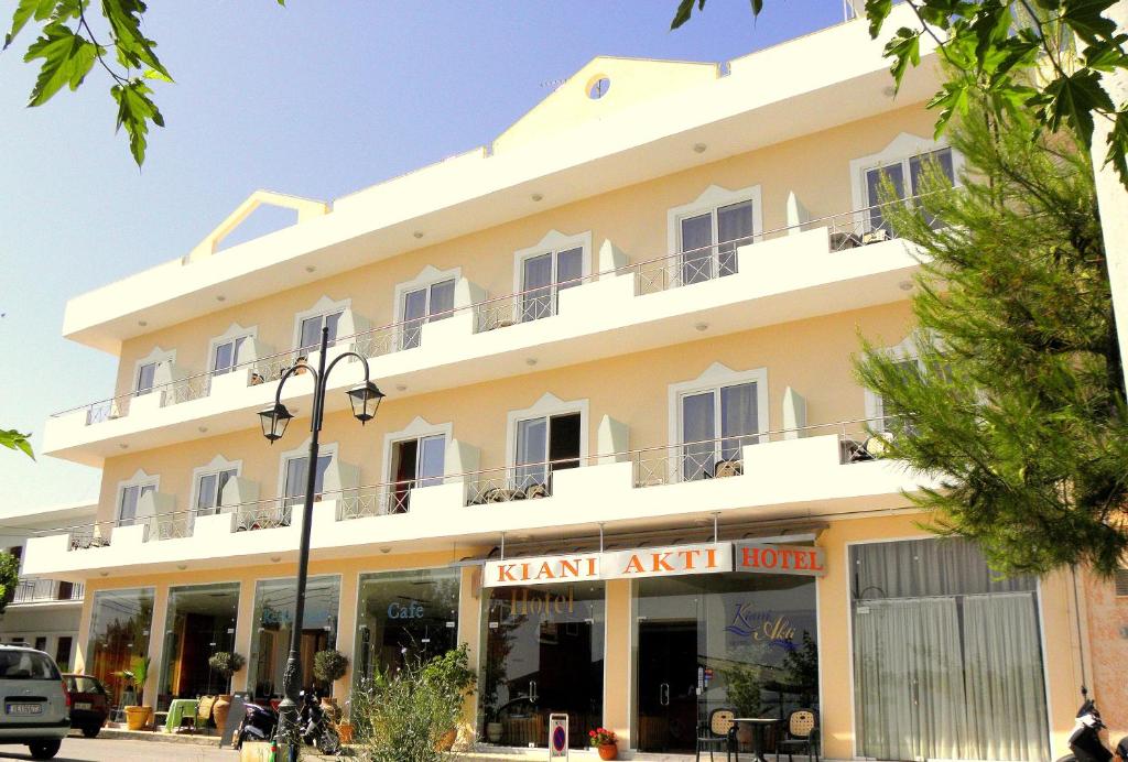 a large white building with a man art hotel at Hotel Kiani Akti in Selianitika