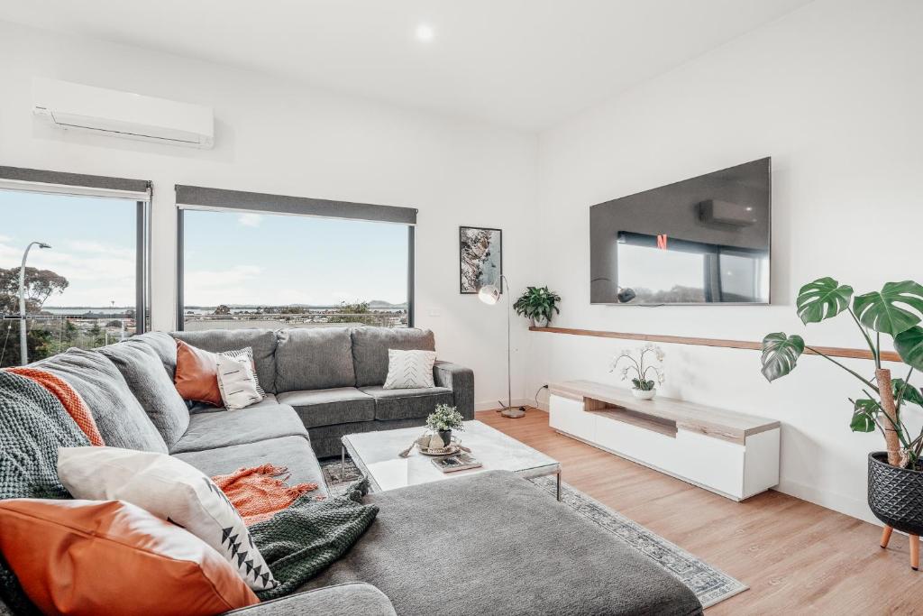 a living room with a couch and a table at Hobart Luxury Family Home with Spa & Fire Pit, Sleeps 8 in Sorell