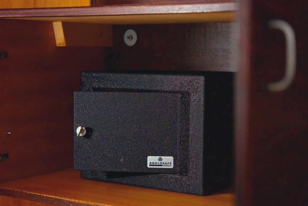 a small black speaker sitting on a wooden shelf at Hotel Merkur - Jablonec nad Nisou in Jablonec nad Nisou