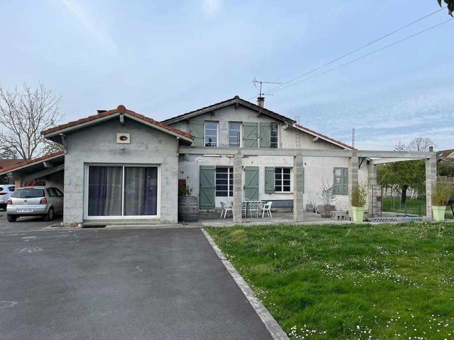 a house with a car parked in a parking lot at Maison PAU - BIZANOS in Bizanos