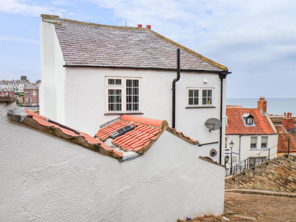 a white house with a red roof at Steps Cottage in Whitby