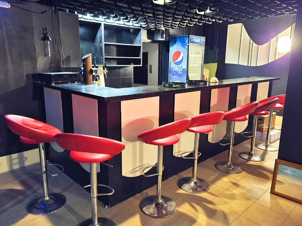 a bar with red bar stools in a kitchen at Hotel Merkur - Jablonec nad Nisou in Jablonec nad Nisou