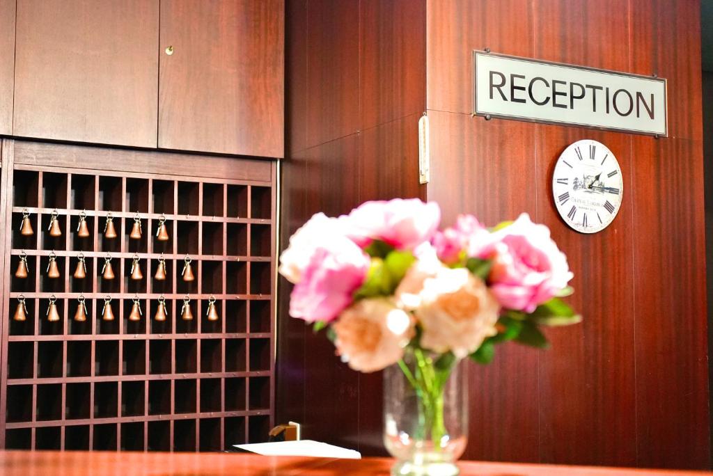 a vase of pink flowers sitting on a table at Hotel Merkur - Jablonec nad Nisou in Jablonec nad Nisou