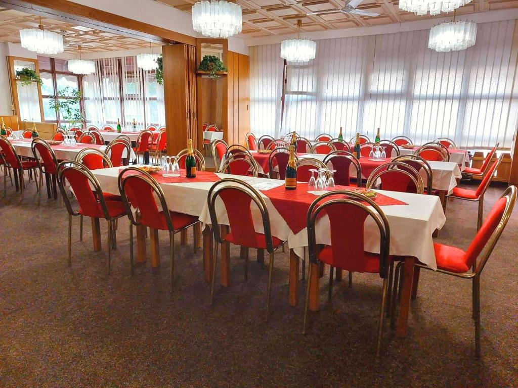a dining room with tables and chairs and chandeliers at Hotel Merkur - Jablonec nad Nisou in Jablonec nad Nisou