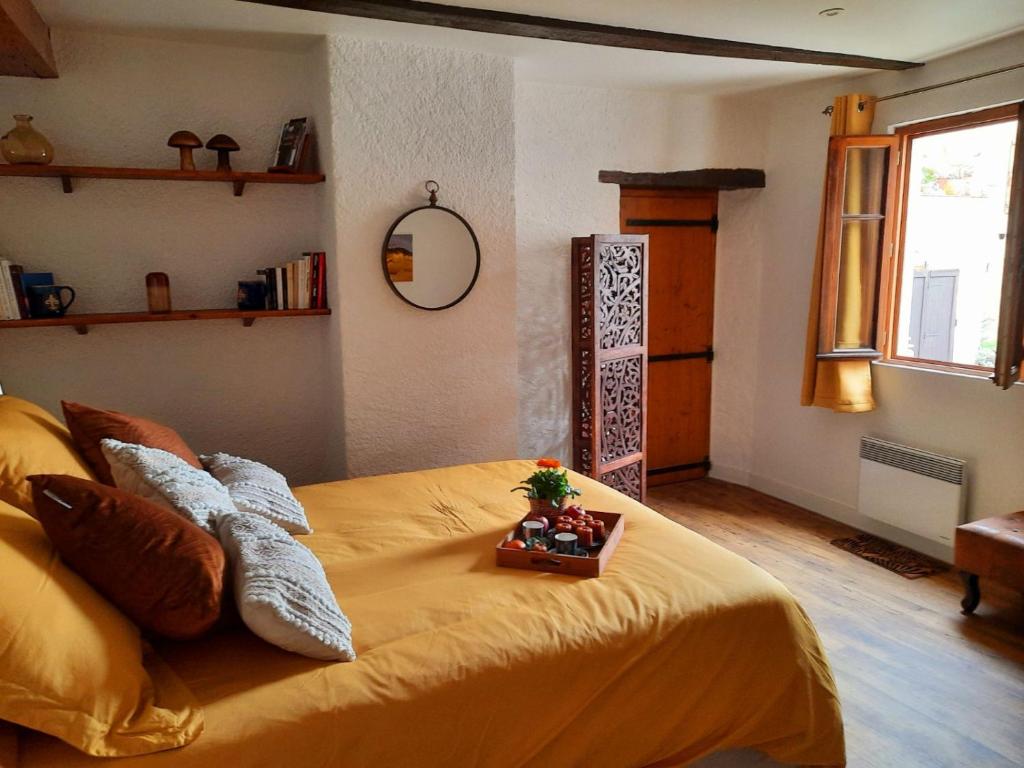 une chambre avec un lit avec un couvre-lit jaune dans l'établissement La maison du tailleur de pierre, à Cordes-sur-Ciel