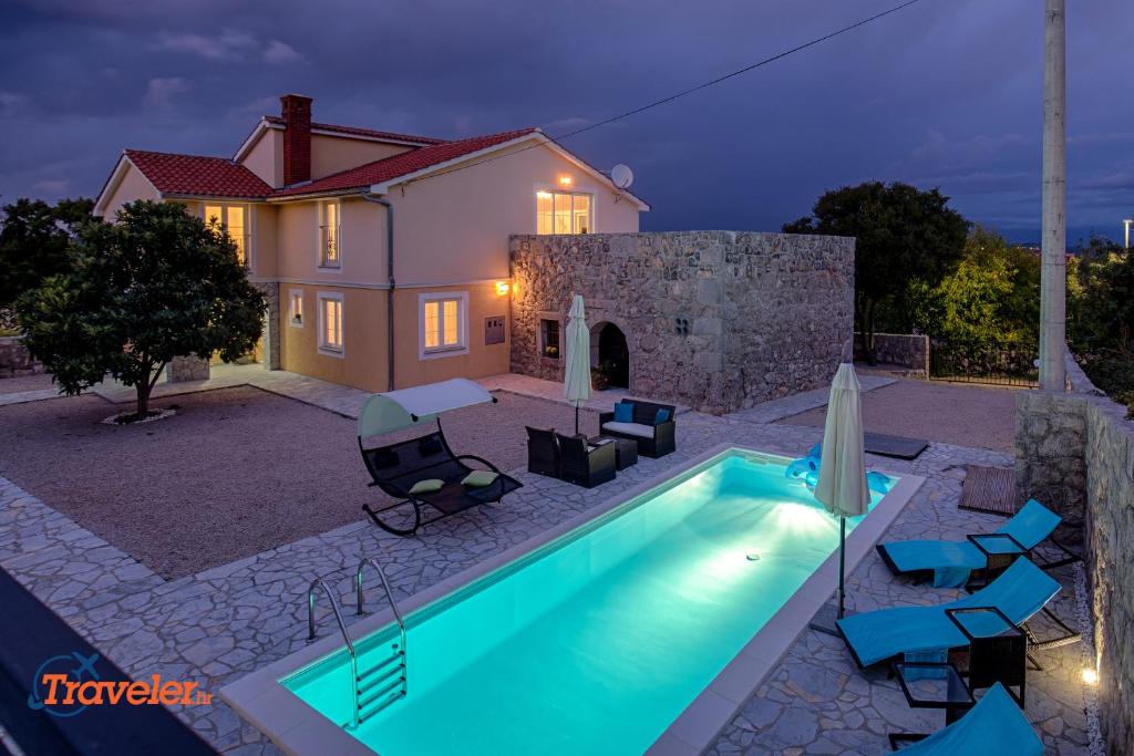 a swimming pool in front of a house at Luxury and modern villa with pool near beach by Traveler tourist agency Krk - ID 2138 in Vrh