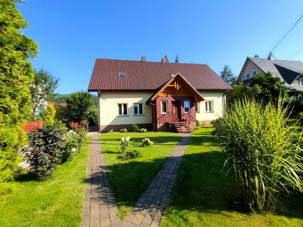 a house with a brick path in the yard at Pokoje gościnne Zawoja Centrum Henryk Hadka in Zawoja