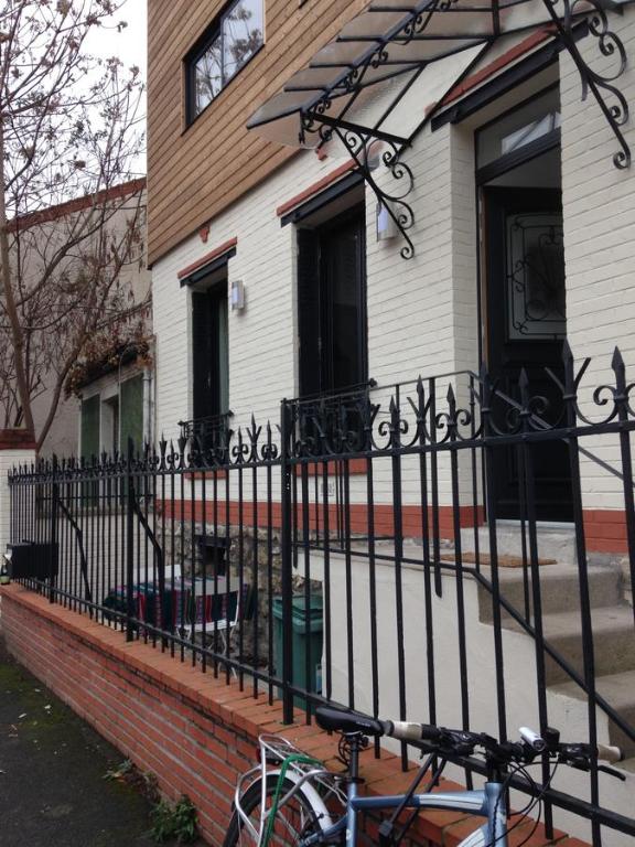 a black fence in front of a house at Appartement Comme Une Petite Maison in Malakoff