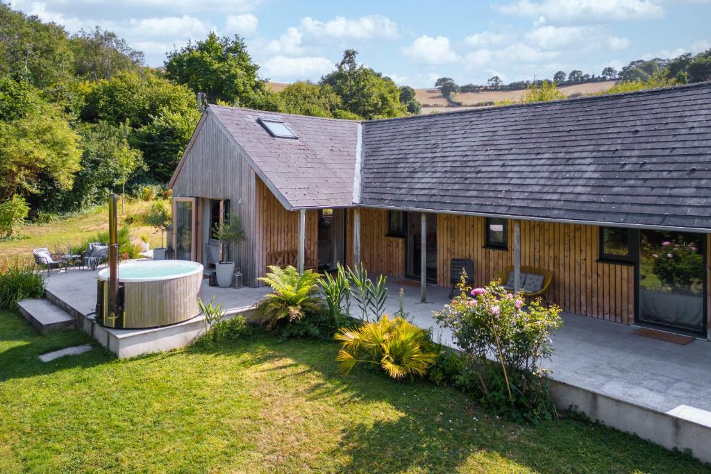 a wooden house with a hot tub in the yard at Sunnybrook - A luxurious Carbon Neutral House close to beach, Shaldon in Shaldon
