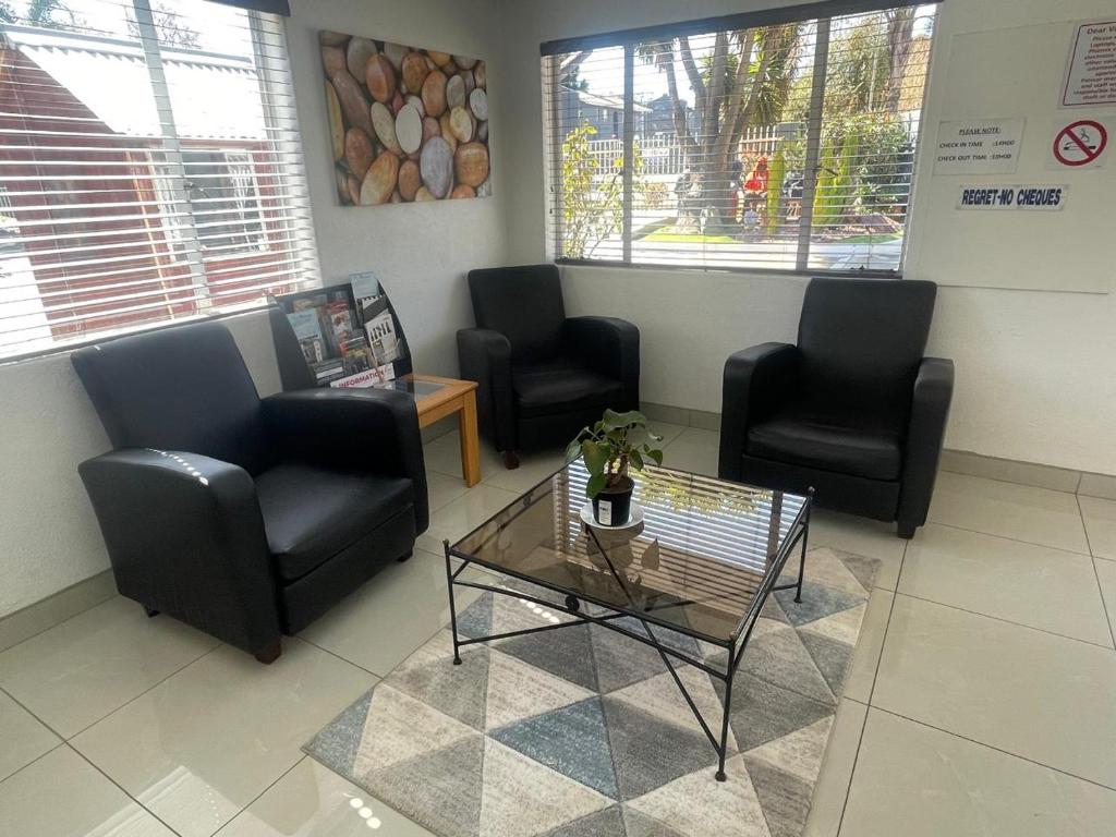 ein Wartezimmer mit Stühlen und einem Tisch im Wartezimmer in der Unterkunft Palmar Hotel in Johannesburg